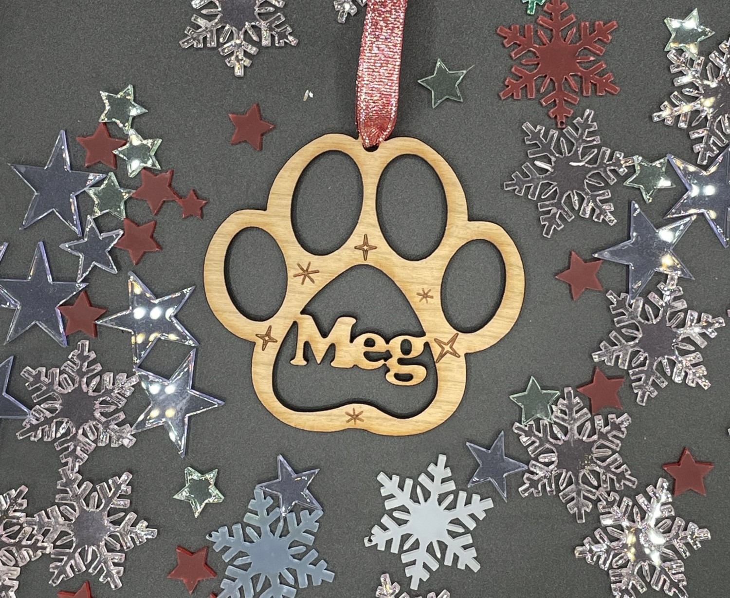 This is a wooden paw print decoration with the name Meg in the middle.
