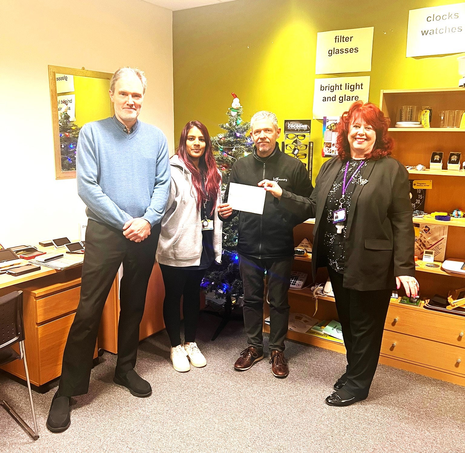 This picture shows members of the Beacon team receiving a cheque from a representative of Thomas Dudley in our low vision hub.