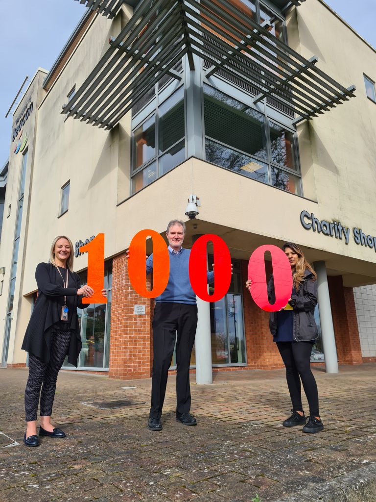 This shows members of our Engagement team holding up a sign that reads 1000