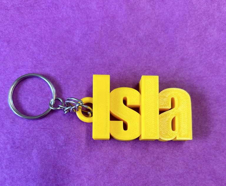 A keyring with bright yellow letters spelling the name Isla