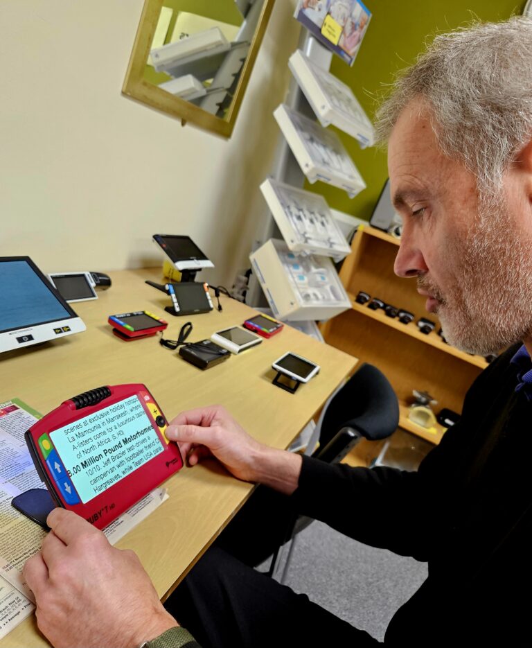 This shows a man using a video magnifier.